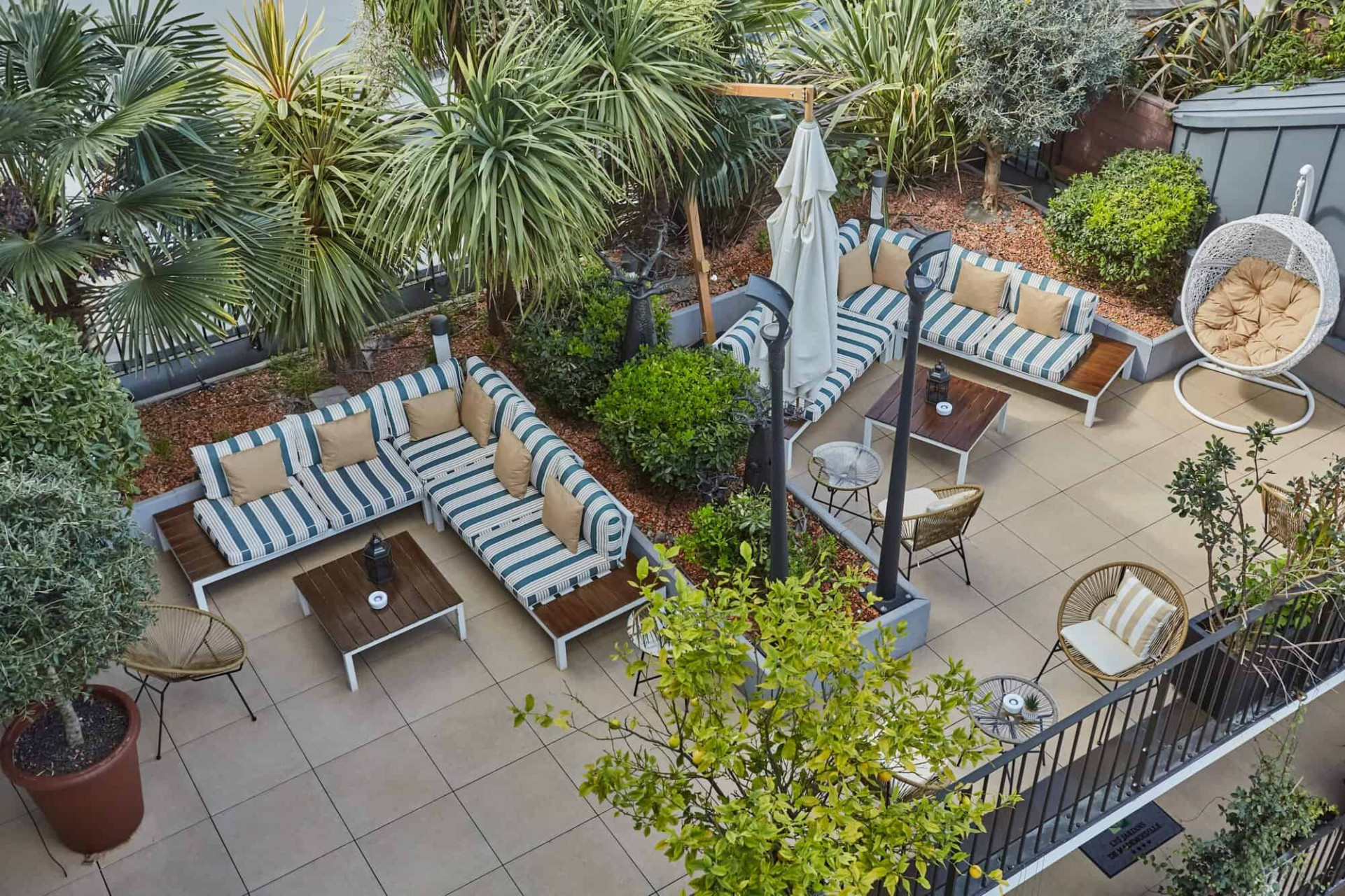 Azotea del hotel Les Jardins de Mademoiselle con diversas plantas y sofás y sillones. 